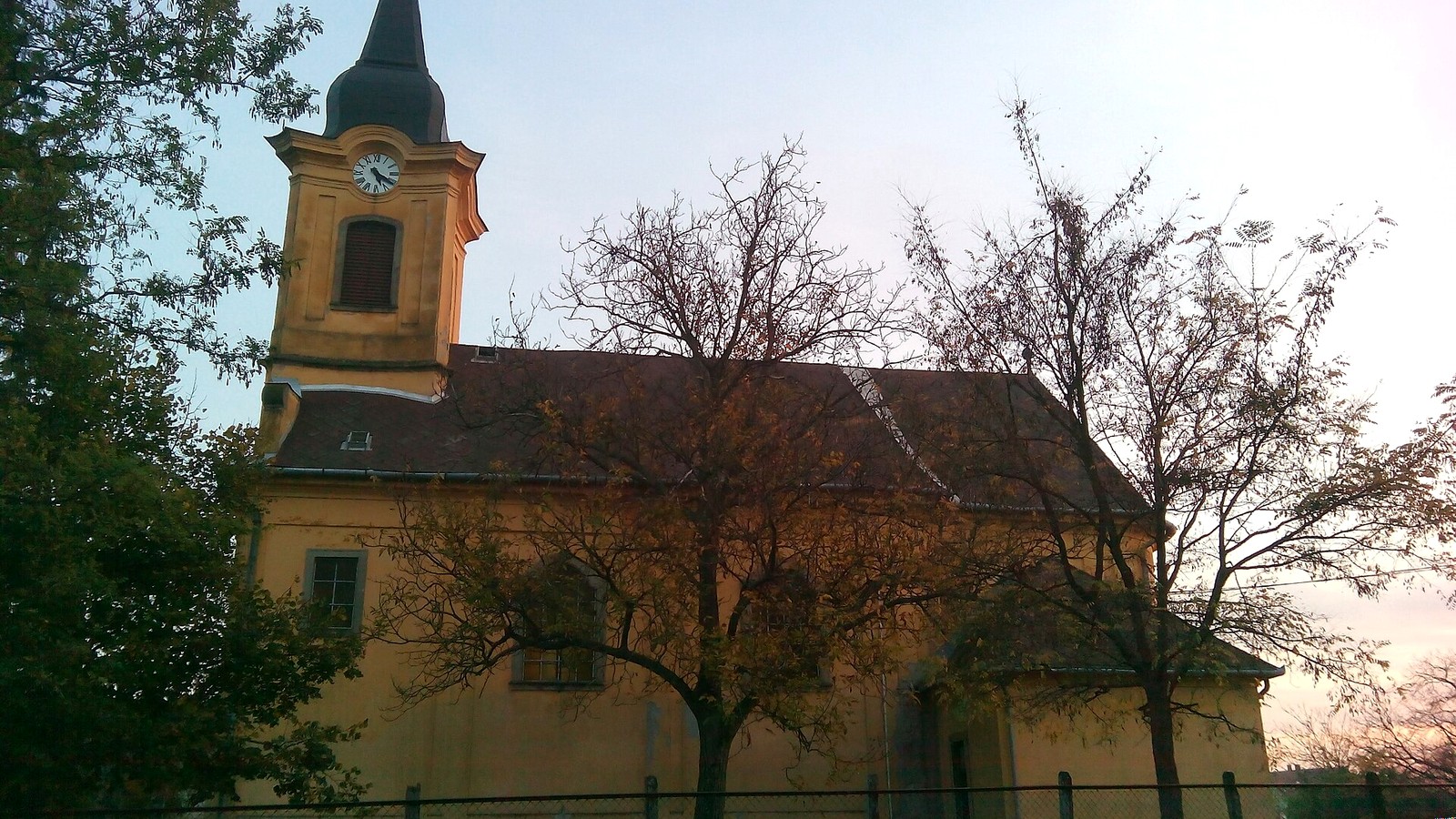 Dormánd, a római katolikus templom fák között, a templomkerttel.