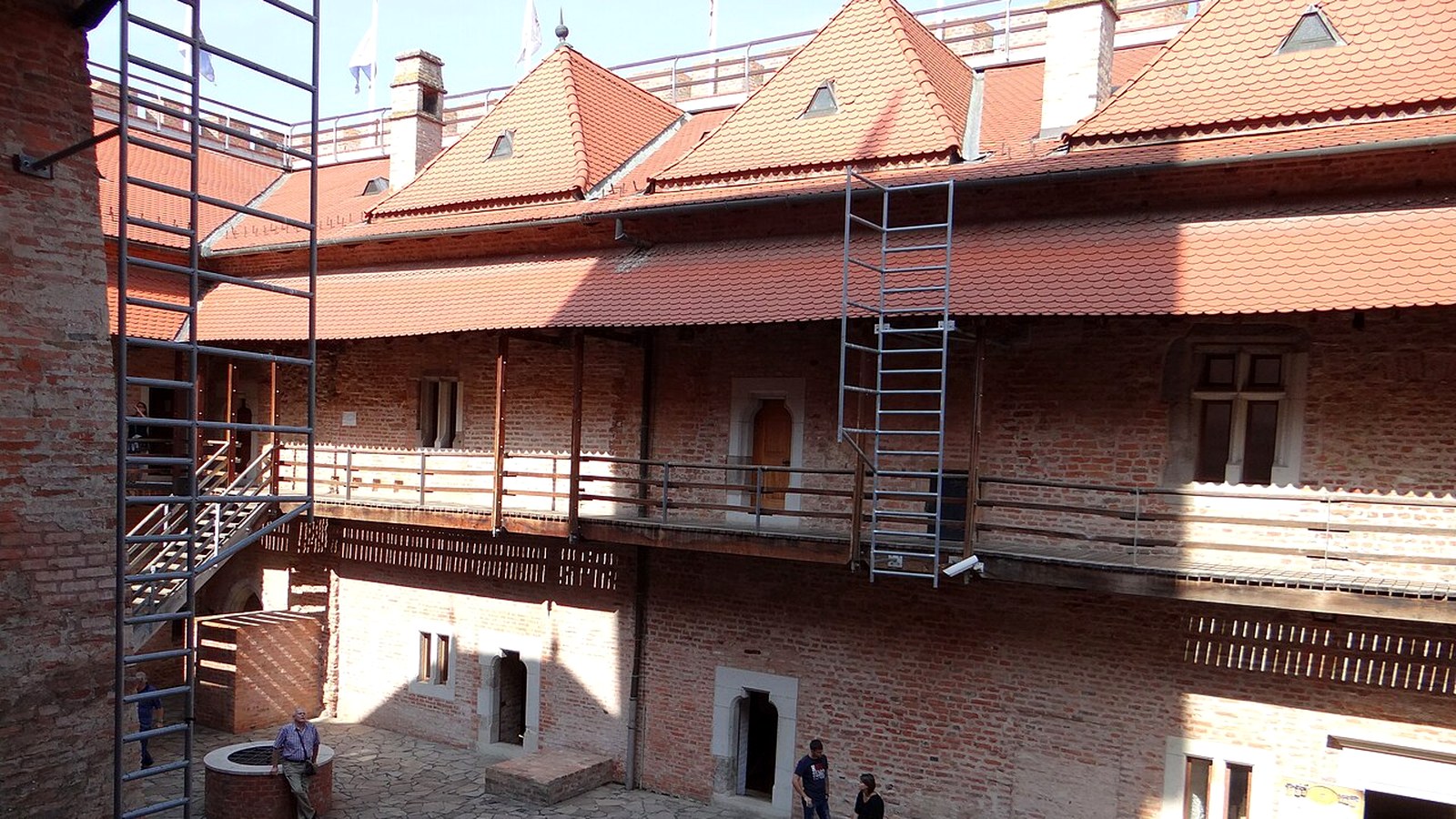 Gyula, a téglavár belső udvara faerkéllyel és piros cseréptetővel, a falakon állványzat.