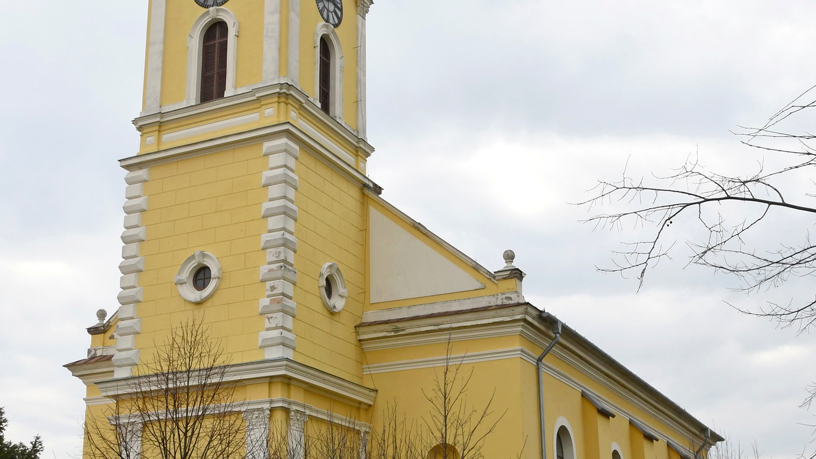 A jászszentlászlói Szent László római katolikus templom sárga tornya — szabadon megközelíthető falusi templomtér.