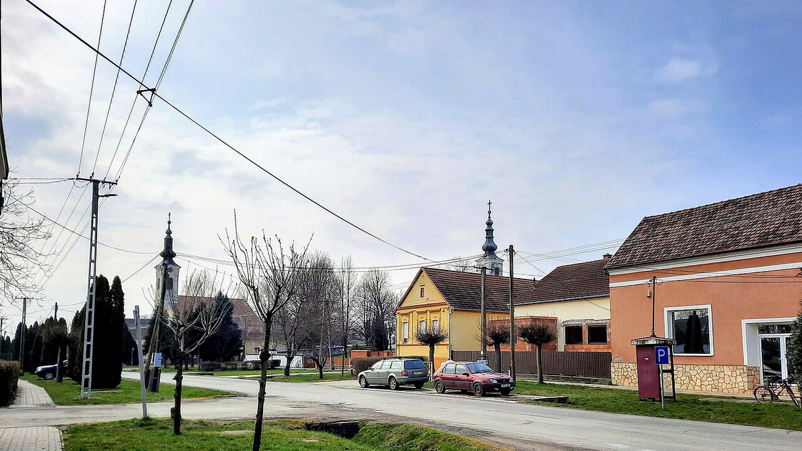 Lippó két templomtornya — katolikus és szerb ortodox templom kültere, szabadon megközelíthető falusi templomterek.
