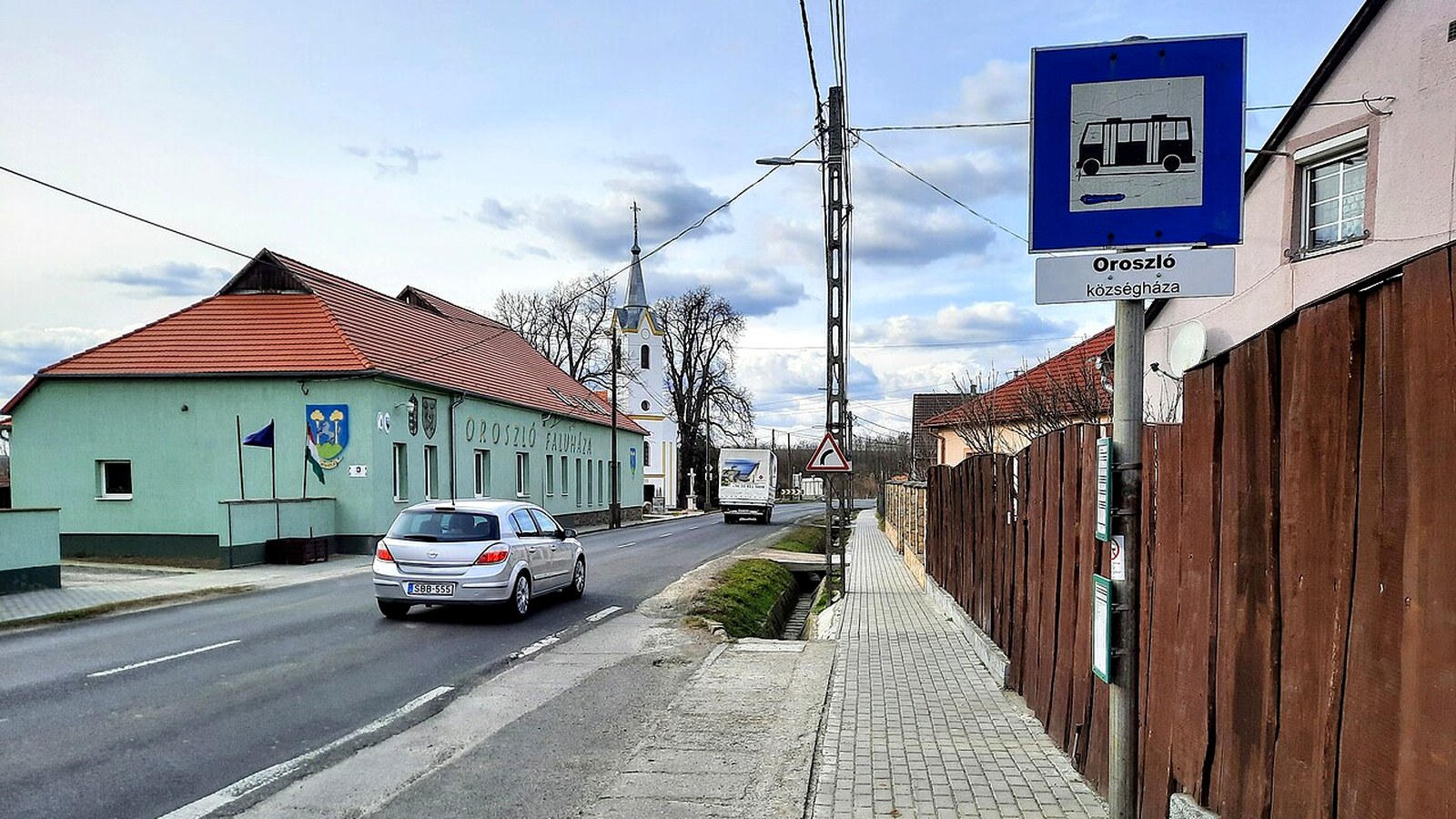 Az oroszlói templom kültere a faluközpontban — szabadon bejárható templomtér és utcakép.