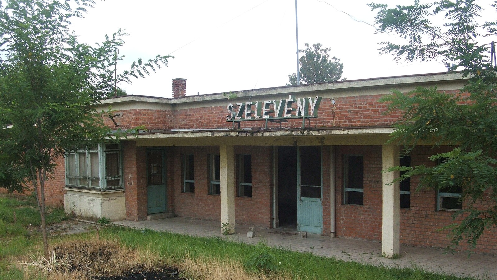 Szelevény, a vasútállomás épülete a település nevét viselő felirattal.