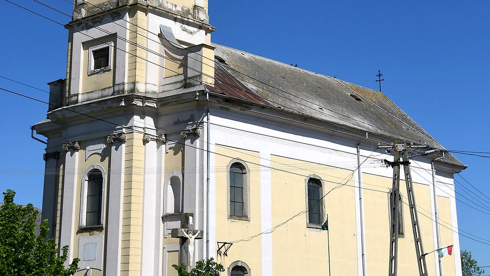 Tarnaszentmiklós, a magas tornyú római katolikus templom a templomkerttel.